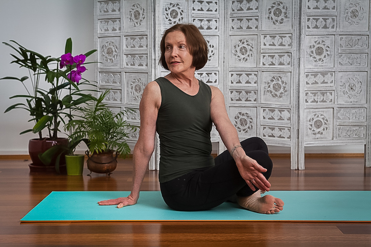 Older yoga student in seated twist